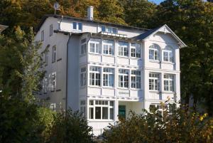 a white house with a lot of windows at Dünenhaus Sellin in Ostseebad Sellin