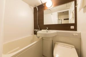 ein Badezimmer mit einem Waschbecken, einem WC und einem Spiegel in der Unterkunft Princess Garden Hotel in Nagoya