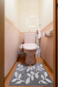 Baño pequeño con aseo y alfombra en ABC Guest House, en Izumisano