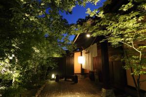 une allée la nuit avec un feu de rue et des arbres dans l'établissement Shinwaen, à Aso