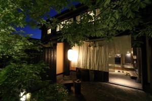 uma vista para uma casa à noite com uma janela em Shinwaen em Aso