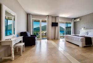 a hotel room with a bed and a desk with a view at Ponti Beach Hotel in Vasiliki