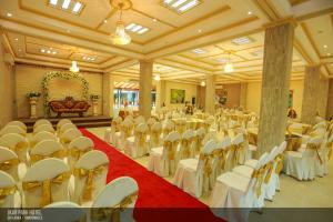 a large banquet hall with white tables and chairs at JKAB Park Hotel in Trincomalee