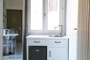 una cucina bianca con lavandino e specchio di Myrtha bb a Bologna Altre 15 foto