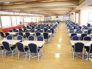Itoen Hotel Atagawa في هيغاشيزو: غرفه كبيره فيها طاولات وكراسي