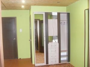 プシュキンスキエ・ゴリにあるGuest houseの鏡とクローゼット付きの緑の部屋