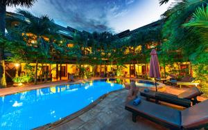 a large swimming pool with chairs and a building at Pavillon Indochine Boutique - Hotel in Siem Reap