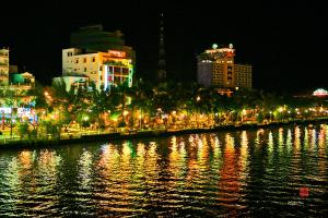 a city at night with lights on the water at Mỹ Ngọc Hotel in Can Tho