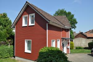 ein rotes Haus mit weißen Fenstern im Hof in der Unterkunft Ferienwohnung Martin 2 in Bad Harzburg