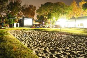 a sandy beach at night with a large screen at Backpackers Inn On The Beach in Byron Bay