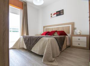 ポルトシンにあるApto Playa de Coiraのベッドルーム1室(赤い枕のベッド1台付)