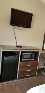 a entertainment center with a flat screen tv on a wall at Econo Inn Lackland AFB-Seaworld San Antonio in San Antonio