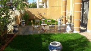 um pátio com cadeiras e vasos na relva em Luxor Star Apartments em Luxor