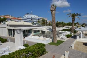 una mujer parada frente a un resort con una palmera en Incantea Resort en Tortoreto Lido