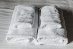 two white towels sitting on top of a bed at Number 6 Nijo in Kyoto