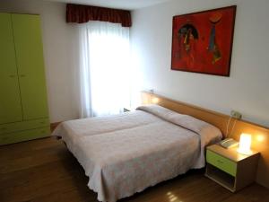 um quarto com uma cama grande e uma janela em Albergo Dolomiti em Fiera di Primiero