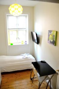 a bedroom with a bed and a desk and a window at Rent a Room Copenhagen in Copenhagen