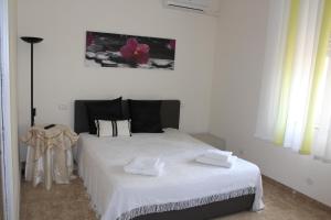 ヴァルデーリチェにあるValderice Rio Apartmentsのベッドルーム1室(白いベッド1台、タオル2枚付)