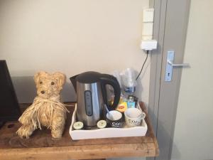 a teddy bear sitting next to a coffee maker on a table at La Maison aux Hortensias in Verneuil-en-Bourbonnais