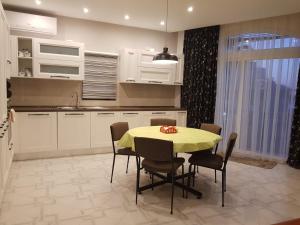 uma cozinha com uma mesa com cadeiras e um lavatório em Merhba APT 3 em Marsalforn