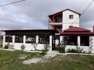 un edificio blanco con techo rojo en Vila la Celeste en Costinesti