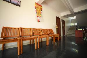 a row of wooden benches sitting in a room at Indeevaram Residency in Trivandrum