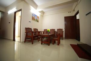 a dining room with a wooden table and chairs at Indeevaram Residency in Trivandrum