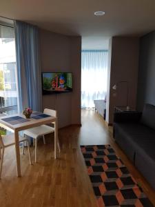 ein Wohnzimmer mit einem Tisch und einem Sofa in der Unterkunft Apartamentai Elija Plus in Šventoji