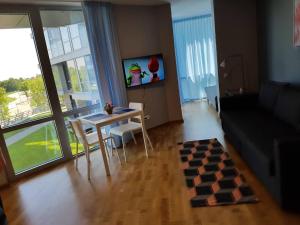 ein Wohnzimmer mit einem Tisch und einem Schachbrett in der Unterkunft Apartamentai Elija Plus in Šventoji