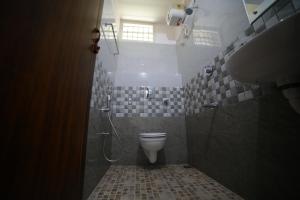 a bathroom with a toilet and a shower and a sink at Indeevaram Residency in Trivandrum +37 photos
