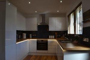 a kitchen with white cabinets and a stove top oven at Beach View in Nairn