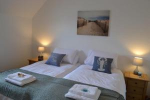a bedroom with two beds with towels on them at Beach View in Nairn