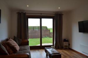 a living room with a couch and a large window at Beach View in Nairn