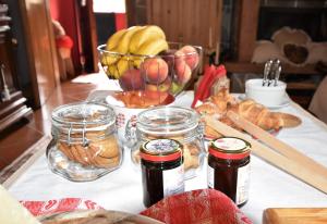 a table with jars of jam and a basket of fruit at A casa di Ada B&B in Campolongo
