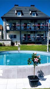 a house with a swimming pool in front of a building at Enjoyit Rooms in Velden am Wörthersee