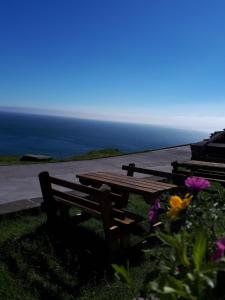 a wooden picnic table with a view of the ocean at Old Irish farmhouse in Dingle