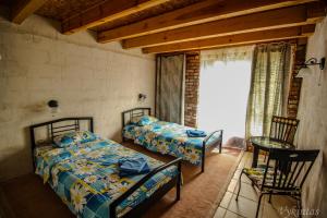 a bedroom with two beds and a table and a window at Rusnietis in Rusnė