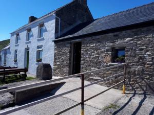 un edificio de piedra con un banco al lado en Old Irish farmhouse en Dingle