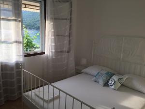 a small bedroom with a bed and a window at Jerkovic Apartment in Žuljana