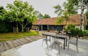 a patio with a table and chairs and a house at Rusnietis in Rusnė
