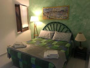 una camera da letto con un letto verde e asciugamani di Casa La Pelosa Beach a Stintino