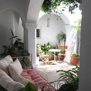 ベヘール・デ・ラ・フロンテーラにあるSiete Balcones y un patioのリビングルーム(ソファ、植物テーブル付)