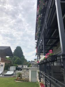 a house with flowers on the side of it at Enjoyit Rooms in Velden am Wörthersee