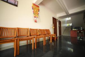 a room with wooden chairs and a painting on the wall at Indeevaram Residency in Trivandrum