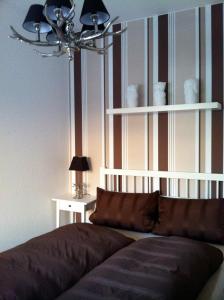 1 dormitorio con sofá y pared a rayas en Pension Gablenz en Chemnitz