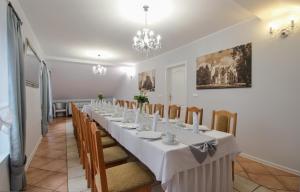 a long dining room with a long table and chairs at Zajazd Różany in Laski