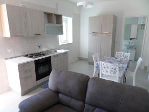 a living room with a couch and a kitchen at La Finestra sul Mare Locazione Turistica in Monte SantʼAngelo +34 photos