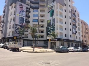 un grand bâtiment avec des voitures garées dans un parking dans l'établissement Location appartement Oran Akid lotfi, à Oran