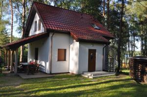 a small white house with a red roof at Apartament pod Dębem in Bobolice +31 photos