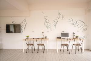 ein Esszimmer mit Stühlen und einem Tisch mit Blättern an der Wand in der Unterkunft The Dearly Koh Tao Hostel-PADI 5 Star Dive Resort in Ko Tao